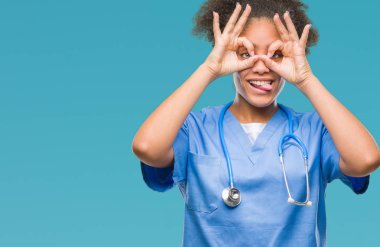 Genç afro Amerikalı doktor kadın dilini, parmaklarının arasından baktığını yapışmasını dürbün gibi ok jest yapıyor izole arka plan yüzünden. Deli ifade.