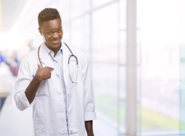 Afro-Amerikan delikanlı bir sürpriz yüz işaret parmağı kendisine Doktor palto giyiyor