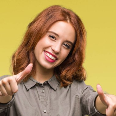 Genç güzel kadın el ile pozitif jest yapıyor onaylama izole arka plan üzerinde başparmak gülümseyen ve başarı için mutlu. Kamera, kazanan jest arıyorsunuz.