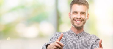 Onaylama genç hipster adam el ile pozitif jest yapıyor gülümseyen ve başarı için mutlu yaşasın. Kamera, kazanan jest arıyorsunuz.