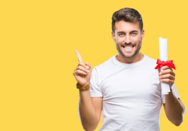 Yakışıklı delikanlı derecesi izole arka plan üzerinde çok mutlu el ve parmak ile tarafına işaret tutan