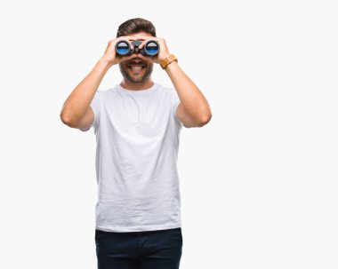 Yakışıklı delikanlı dürbün ile izole arka plan üzerinde duran ve diş gösterilen kendine güvenen bir gülümsemeyle gülümseyerek mutlu bir yüz ile seyir