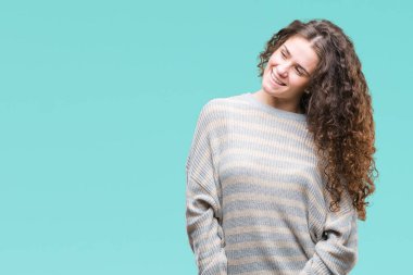 Güzel esmer kıvırcık saçlı Genç kız uzak tarafına yüzünde, doğal ifade gülümseme ile seyir izole arka plan üzerinde kış kazak giyiyor. Kendine güvenen gülüyor.