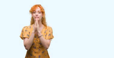 El ele tutusun AF emin gülümseyen için soran ile dua genç Kızıl saçlı kadın.