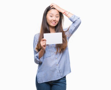 Baş, el ile vurguladı izole arka plan üzerinde boş kartı tutan Genç Asyalı kadın şok utanç ve sürpriz suratla, öfkeli ve sinirli. Korku ve hata için üzgün.