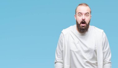 Genç beyaz hipster adam giyiyor spor giyim izole arka plan korkuyor ve şok sürpriz ifade ile üzerinde korku ve yüz heyecanlı.
