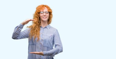 Eller eller büyük gösterilen ve büyük boy işareti, ölçü birimi sembolü ile genç redhead bussines kadın. Kameraya bakarak gülümsüyordu. Ölçüm kavramı.