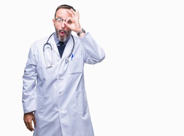 Orta yaş üst düzey ağarmış Doktor adam giyen Tıbbi üniforma Tamam jest sürpriz yüz, göz parmaklarının arasından seyir şok yapıyor arka plan izole. İmansız ifade.