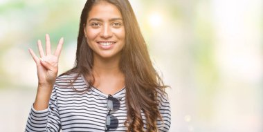 Genç güzel Arap kadın üzerinde güneş gözlüğü takıyor gösterilen arka plan izole ve parmakları ile işaret kendinden emin ve mutlu gülümseyerek süre dört numara.