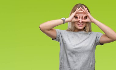 Dilini, parmaklarının arasından baktığını yapışmasını dürbün gibi ok jest yapıyor izole arka plan üzerinde beyaz kadın. Deli ifade.