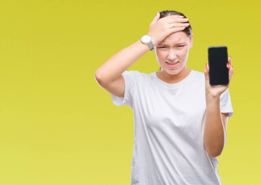 Genç güzel beyaz kadın Smartphone ekran başında, el ile vurguladı izole arka plan üzerinde gösterilen şok utanç ve sürpriz suratla, öfkeli ve sinirli. Korku ve hata için üzgün.
