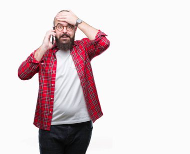 Smartphone kafa üzerinde el ile vurguladı izole arka plan üzerinde konuşan genç beyaz hipster adam şok utanç ve sürpriz suratla, öfkeli ve sinirli. Korku ve hata için üzgün.