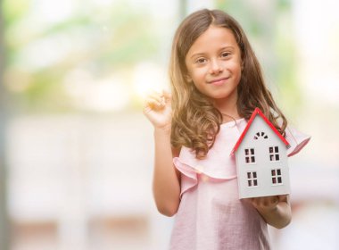 Küçük ev çok mutlu el ve parmak ile tarafına işaret tutan esmer Latin kız