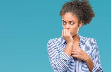 Stresli ve gergin ile eller tırnak ısırma dudaklarından seyir izole arka plan üzerinde genç afro Amerikalı kadın. Anksiyete sorunu.