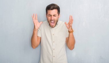 Yakışıklı delikanlı deli ve silah ile başarı için deli gömleği yaz kutluyor giyen gri grunge duvarın üzerinden kaldırdı ve heyecanlı çığlık gözler kapalı. Kazanan kavramı