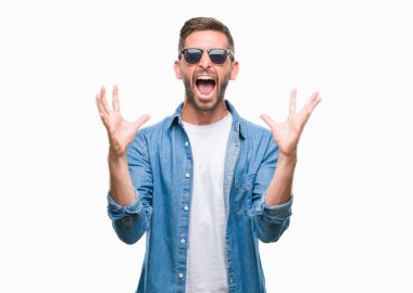 Yakışıklı delikanlı deli ve silah ile başarı için deli kutluyor izole arka plan üzerinde güneş gözlüğü takıyor kaldırdı ve heyecanlı çığlık gözler kapalı. Kazanan kavramı