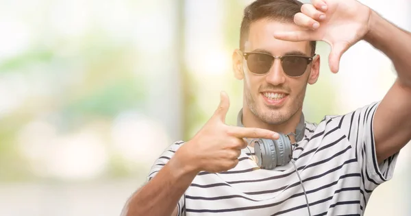 Hombre Joven Guapo Con Auriculares Sonriendo Haciendo Marco Con Manos —  Fotos de Stock