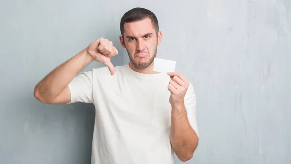 Joven Caucásico Hombre Sobre Gris Pared Grunge Mostrando Tarjeta Visita —  Fotos de Stock