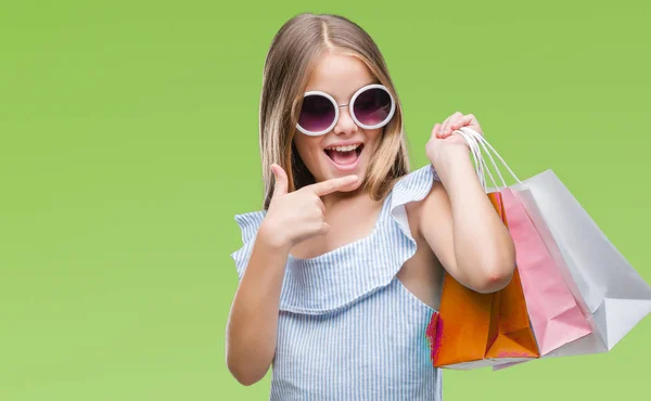 非常に幸せな手と指で指している孤立した背景の上販売ショッピング バッグをもつ美しい少女 — ストック写真