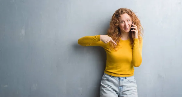 Unga Rödhårig Kvinna Över Grå Grunge Vägg Pratar Telefon Med — Stockfoto
