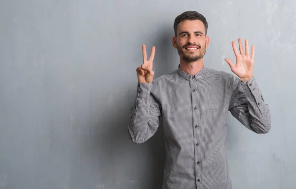 Joven Hombre Adulto Pie Sobre Pared Grunge Gris Mostrando Apuntando —  Fotos de Stock