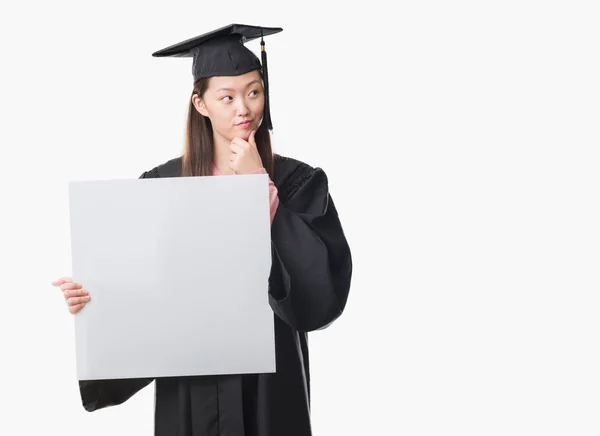 Mladá Číňanka Postgraduální Uniformě Drží Nápis Vážná Tvář Přemýšlet Otázku — Stock fotografie