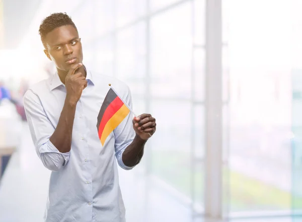 ドイツの旗深刻な顔を考えて質問 非常に混乱して考えを保持している若いアフリカ系アメリカ人 — ストック写真