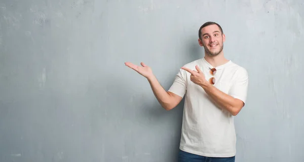 Joven Hombre Caucásico Sobre Pared Grunge Gris Con Gafas Sol — Foto de Stock