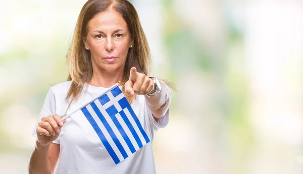 中年カメラと指で指している孤立した背景にギリシャのヒスパニック系女性持株の旗 手に署名 正面からポジティブで自信のジェスチャー — ストック写真