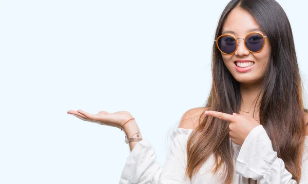 Young Asian Woman Wearing Sunglasses Isolated Background Amazed Smiling Camera — Stock Photo, Image