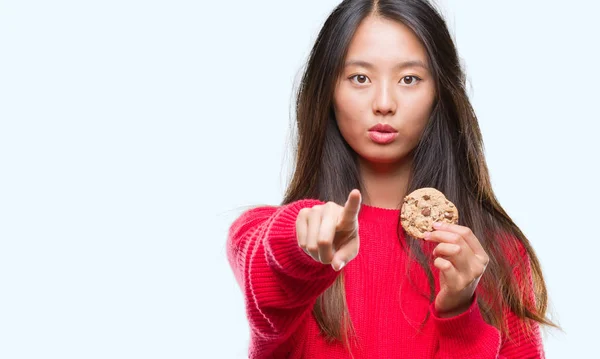 Joven Mujer Asiática Comiendo Galletas Chocolate Sobre Fondo Aislado Señalando —  Fotos de Stock