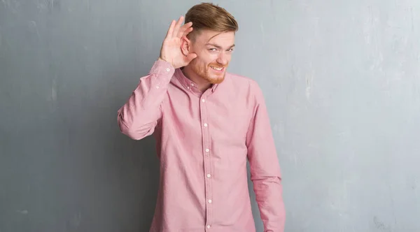 Homem Ruivo Jovem Sobre Parede Grunge Cinza Vestindo Camisa Rosa — Fotografia de Stock