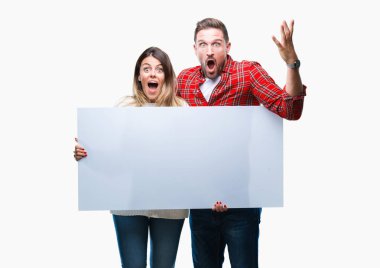 Boş başlık büyük gülümseme ile çığlık zaferini kutluyor ve ellerini kaldırdı izole arka plan çok mutlu ve heyecanlı, kazanan ifade üzerinde tutan genç çift