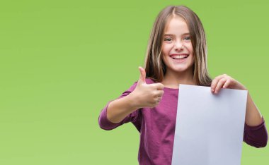 Boş sayfa tutan genç güzel kız izole arka plan üzerinde kocaman bir gülümseme ile ok işareti yaparken mutlu kağıt, parmaklarıyla, mükemmel işaret parmak