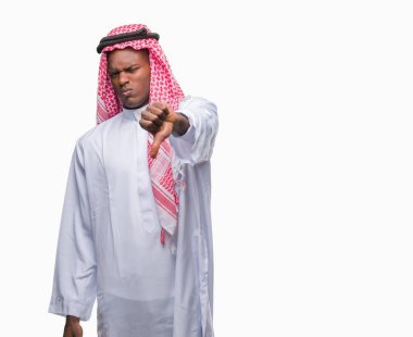 Geleneksel keffiyeh mutsuz ve kızgın ret gösterilen ve başparmak aşağı hareketi ile negatif seyir izole arka plan üzerinde giyen genç Arapça Afrika adam. Kötü ifade.