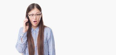 Telefonda şok bir sürpriz yüz, korkuyor ve korku ifadesi ile heyecanlı korkuyor konuşan izole arka plan üzerinde Genç Çinli kadın