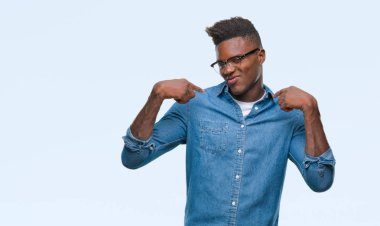 Yüzünde gülümseme ile kendinden emin görünüyorsun, kendini gururlu ve mutlu parmakları ile işaret izole arka plan üzerinde genç Afro-Amerikan adam.