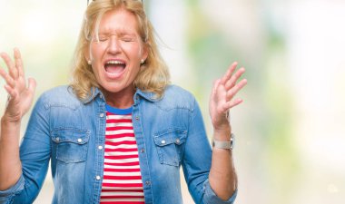 Orta yaş sarışın kadın izole arka plan çılgın ve kızgın bağırarak ve agresif ifade ve silah kaldırdı bağırıyor. Hayal kırıklığı kavramı.