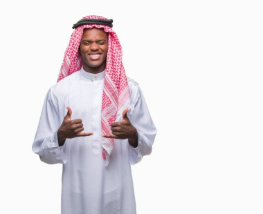 Geleneksel keffiyeh izole arka plan başarı işareti el ile pozitif jest yapıyor üzerinde giyen genç Arapça Afrika adam başparmak gülümseyen ve mutlu. Neşeli bir ifadeyle, kazanan jest kameraya bakıyor.