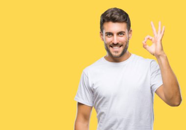 Gülümseyen izole arka plan üzerinde genç yakışıklı adam el ve parmaklar ok işaretiyle yapıyor olumlu. Başarılı ifade.