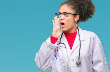 Genç afro Amerikalı doktor kadın bağırarak ve ağzı üzerinde el ile yan için çığlık izole arka plan yüzünden. İletişim kavramı.