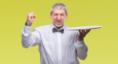 Holding izole arka rahatsız üzerinde gümüş tepsi ve öfke, çılgın ve yükseltilmiş el, öfke kavramı ile diye bağıran ile sinirli bağırarak yakışıklı üst düzey garsonla