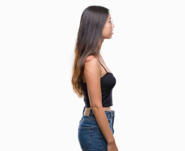 Genç Asyalı kadın gözlük izole arka tarafına, seyir üzerinde dinlenmek doğal yüz emin gülümseme ile pozuyla profili.