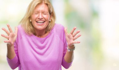 Orta yaş sarışın kadın deli ve silah ile başarı için deli kutluyor izole arka plan üzerinde kaldırdı ve heyecanlı çığlık gözler kapalı. Kazanan kavramı