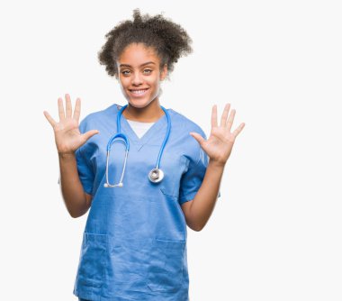 Genç afro Amerikalı doktor kadın gösterilen ve parmakları ile işaret izole arka plan yüzünden kendinden emin ve mutlu gülümseyerek süre on numara.