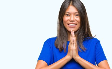 Genç Asyalı kadın birlikte emin gülümseyen bağışlanmak ellerle dua izole arka plan üzerinde.