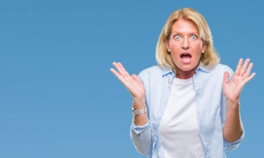 Orta yaş sarışın kadın izole arka plan korkuyor ve sürpriz ifade ile şok yüzünden korku ve yüz heyecanlı.