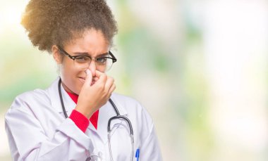 Bir şey pis ve iğrenç kokulu izole arka plan, dayanılmaz koku, holding nefes burun parmaklar ile genç afro Amerikalı doktor kadın. Kötü kokuyor kavramı.