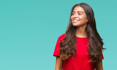 Genç güzel Arap kadın uzak tarafına yüzünde, doğal ifade gülümseme ile seyir izole arka plan yüzünden. Kendine güvenen gülüyor.