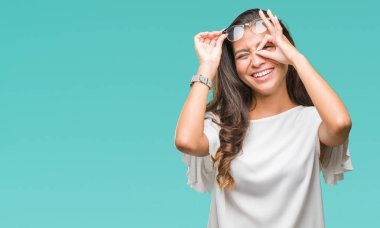 Genç güzel Arap kadın gülümsüyor, parmakları ile mutlu yüz üzerinden seyir göz el ile ok jest yapıyor izole arka plan üzerinde gözlük.